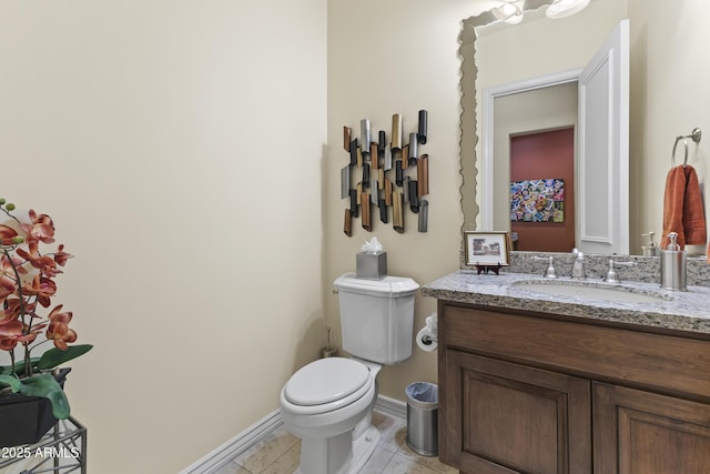 bathroom with toilet, vanity, baseboards, and tile patterned flooring