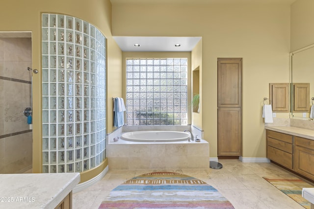 bathroom with walk in shower, a garden tub, vanity, and tile patterned flooring