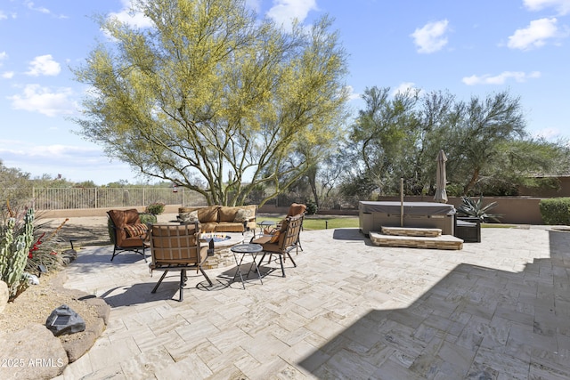 fenced backyard featuring a hot tub, an outdoor living space, and a patio area