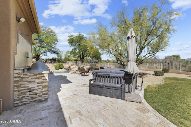 fenced backyard featuring a hot tub, exterior kitchen, and a patio area