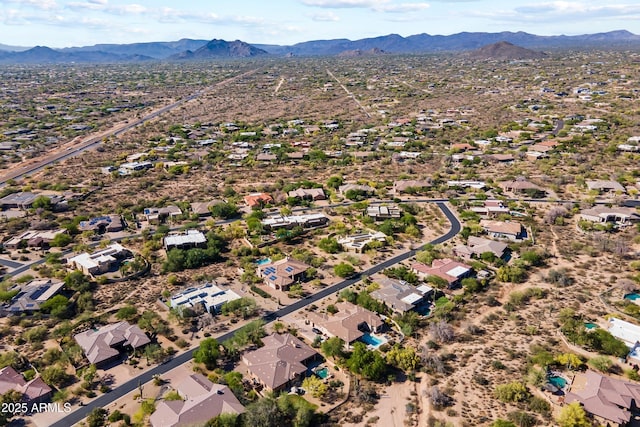 aerial view of property's location with a mountainous background and nearby suburban area