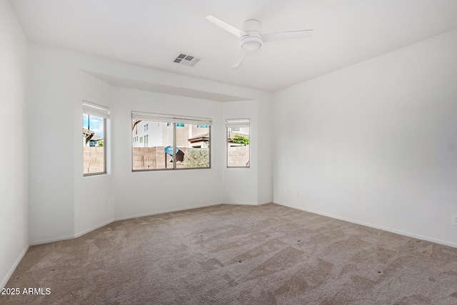 carpeted spare room with plenty of natural light and ceiling fan