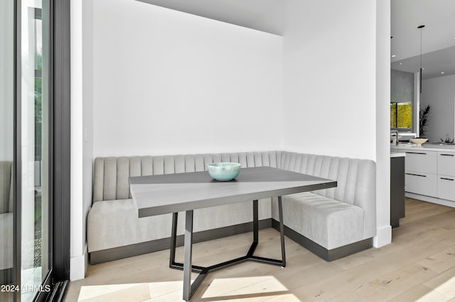 dining room featuring breakfast area, light hardwood / wood-style flooring, a wealth of natural light, and sink