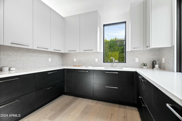 kitchen featuring light hardwood / wood-style floors, white cabinetry, and sink