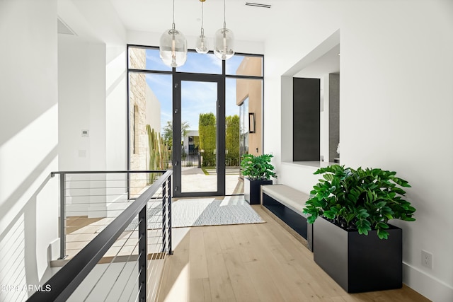 doorway with hardwood / wood-style floors, french doors, and a notable chandelier