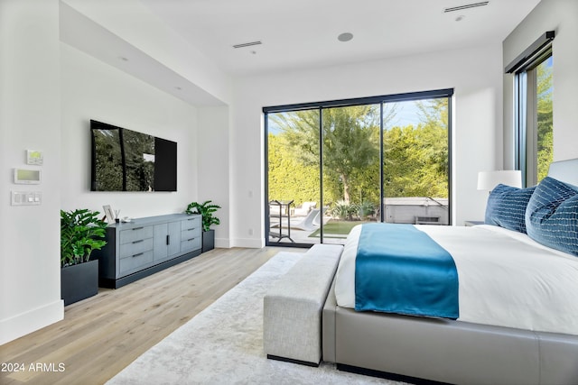 bedroom with access to exterior and light wood-type flooring