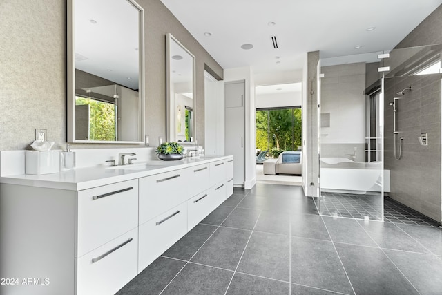 bathroom with tile patterned flooring, vanity, and tiled shower