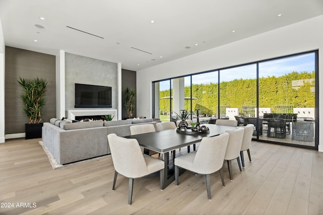 dining space featuring a fireplace and light hardwood / wood-style flooring