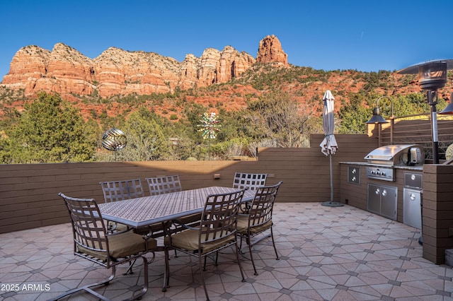 view of patio featuring grilling area, a mountain view, outdoor dining area, and area for grilling