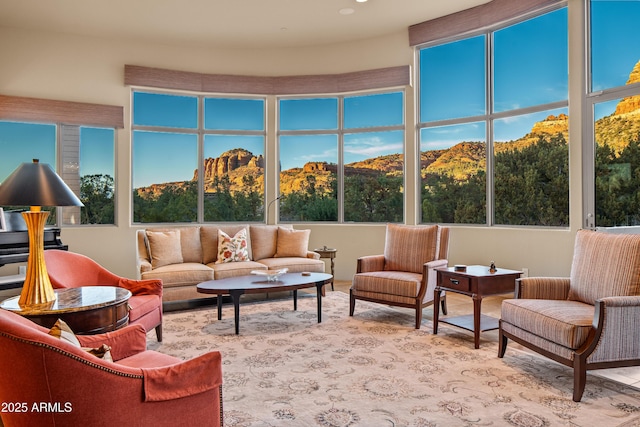 sunroom with a healthy amount of sunlight, a mountain view, and a view of trees