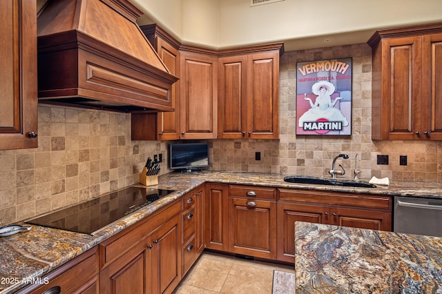 kitchen featuring tasteful backsplash, custom range hood, black electric stovetop, and a sink