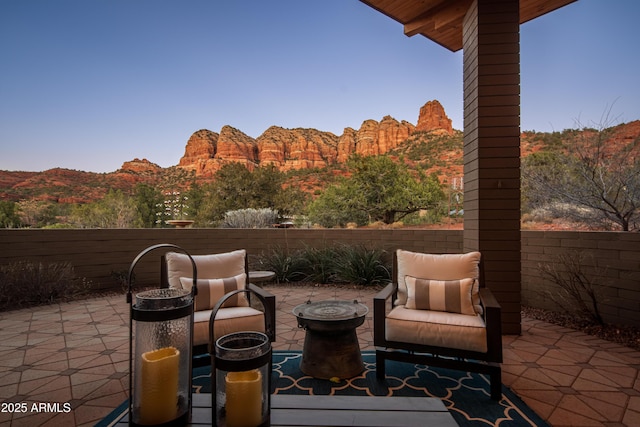 view of patio with a fenced backyard, a mountain view, and a forest view