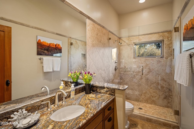 full bathroom with tiled shower, vanity, and toilet