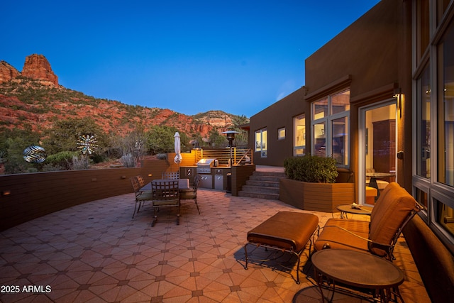 view of patio with outdoor dining area, grilling area, and a mountain view