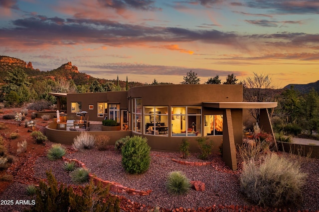 back of house at dusk with stucco siding