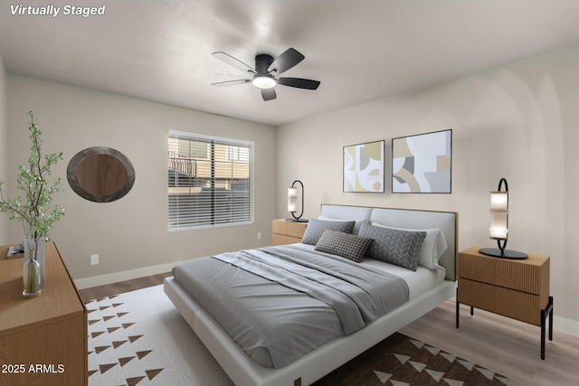 bedroom featuring a ceiling fan, baseboards, and wood finished floors