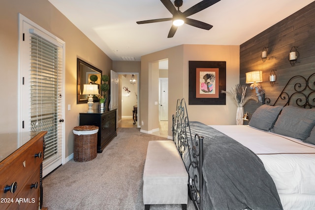 bedroom featuring light colored carpet, ceiling fan, and wood walls