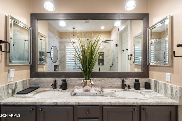 bathroom with vanity, a shower with shower door, and an inviting chandelier