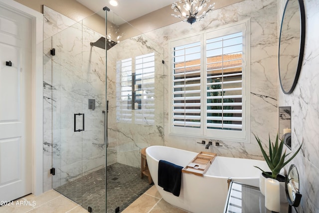 bathroom featuring a chandelier, shower with separate bathtub, and tile patterned flooring