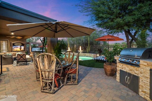 patio terrace at dusk featuring area for grilling, an outdoor living space, ceiling fan, and grilling area