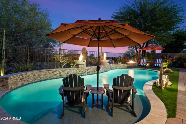 pool at dusk with pool water feature