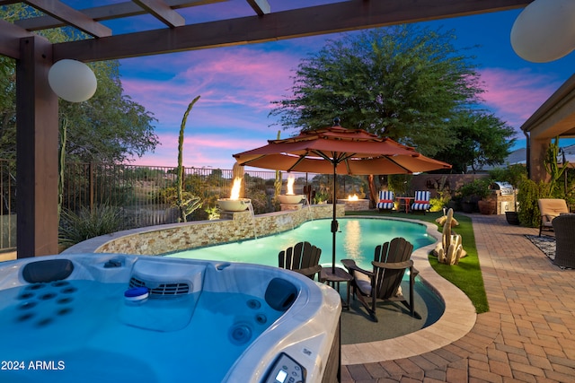 pool at dusk featuring a patio area and a hot tub