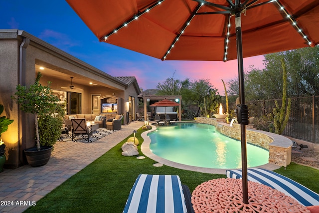 pool at dusk featuring ceiling fan, a patio area, and an outdoor hangout area