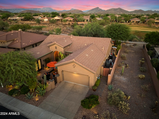 aerial view at dusk featuring a mountain view