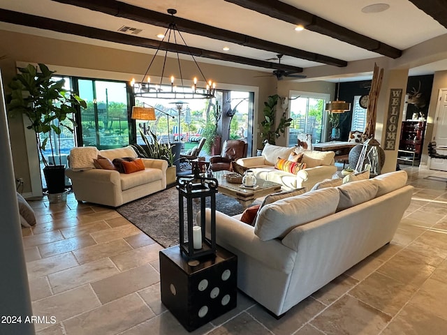 living room with ceiling fan with notable chandelier, beam ceiling, and a wealth of natural light