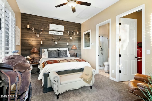 bedroom featuring carpet flooring, connected bathroom, ceiling fan, a wall mounted air conditioner, and wooden walls