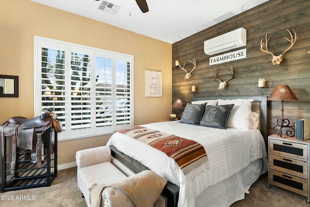 bedroom with ceiling fan, wood walls, an AC wall unit, and carpet floors