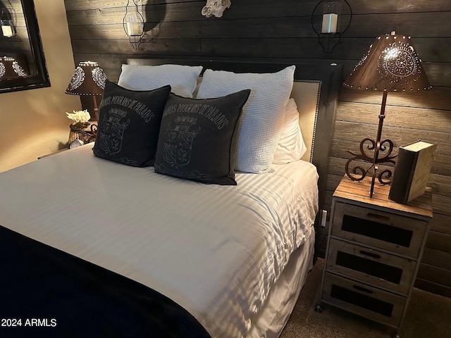 bedroom with wooden walls and dark carpet