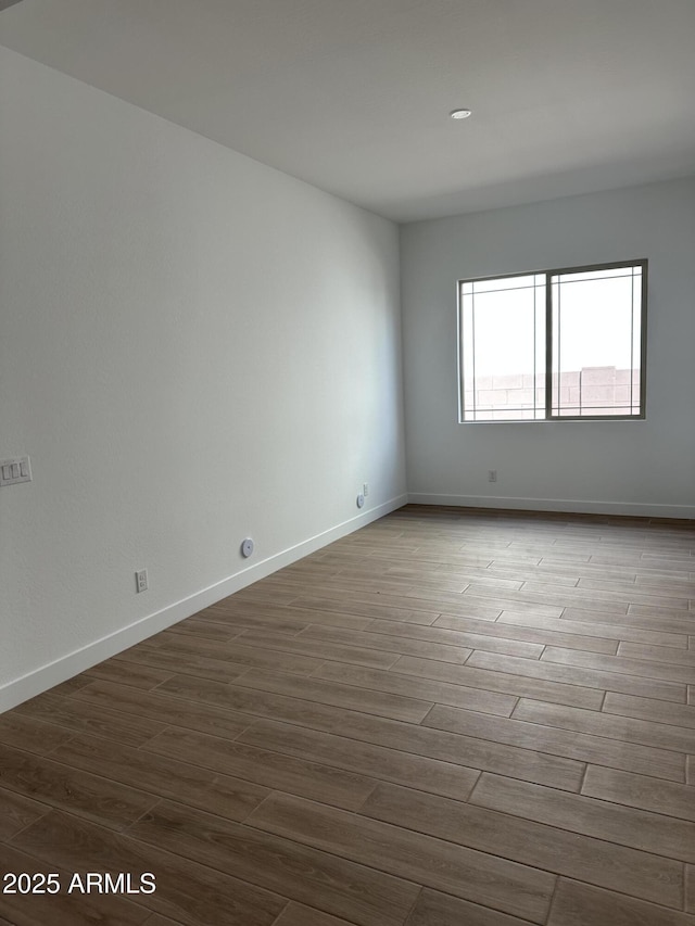 empty room with baseboards and wood finished floors