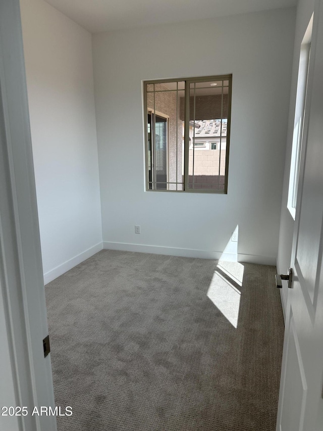 carpeted empty room with baseboards