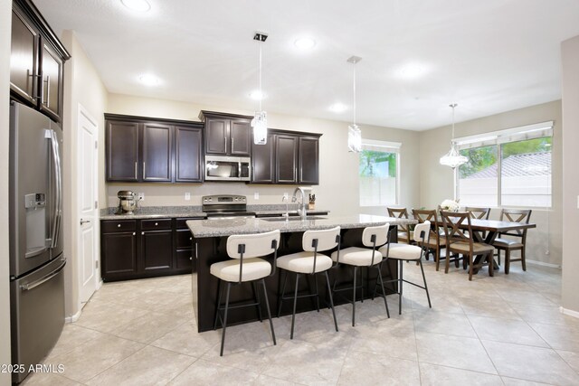 9295 W Wood Dr, Peoria, AZ 85381 - kitchen with a sink, light stone countertops, appliances with stainless steel finishes, and a breakfast bar area