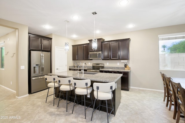 9295 W Wood Dr, Peoria, AZ 85381 - kitchen with dark brown cabinetry, stainless steel appliances, a breakfast bar, and a sink