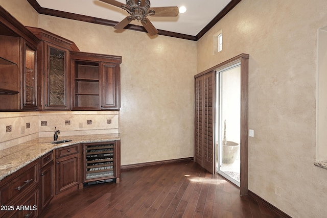 bar featuring light stone countertops, dark hardwood / wood-style flooring, wine cooler, ornamental molding, and dark brown cabinets