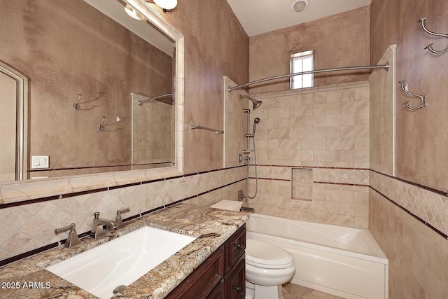 full bathroom with tiled shower / bath, vanity, decorative backsplash, tile walls, and toilet