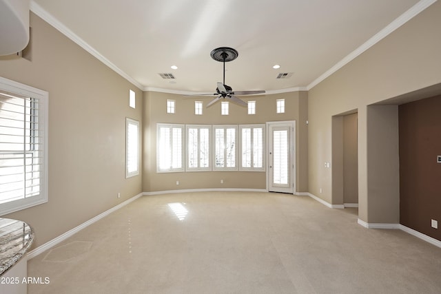 carpeted spare room with ceiling fan and ornamental molding