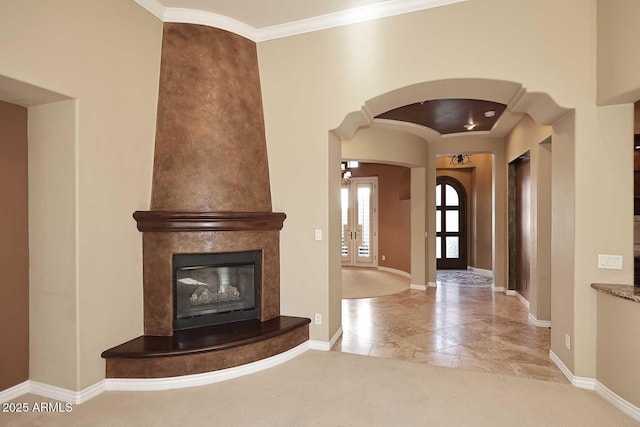 entryway with a fireplace, ornamental molding, and light tile patterned flooring