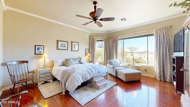 bedroom with baseboards, visible vents, ceiling fan, ornamental molding, and dark wood-style flooring