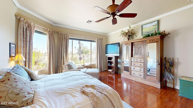 bedroom with dark wood finished floors, visible vents, ornamental molding, ceiling fan, and baseboards