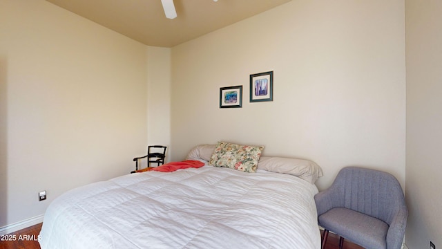 bedroom with a ceiling fan, baseboards, and dark wood-style flooring