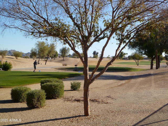 view of community featuring view of golf course and a lawn