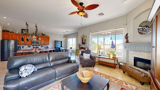 living room featuring light tile patterned floors, recessed lighting, visible vents, a ceiling fan, and a high end fireplace