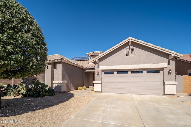 ranch-style home with solar panels, an attached garage, a tile roof, and stucco siding