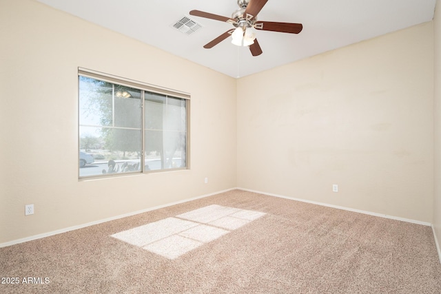 carpeted empty room featuring a ceiling fan, visible vents, and baseboards