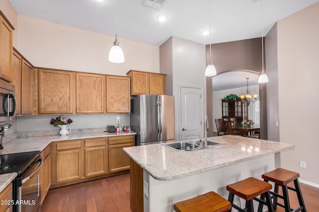 726 E Heather Dr, San Tan Valley, AZ 85140 - kitchen featuring appliances with stainless steel finishes, a sink, dark wood-style flooring, a breakfast bar, and pendant lighting