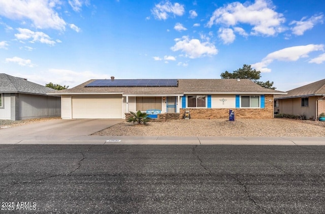 single story home with a garage and solar panels