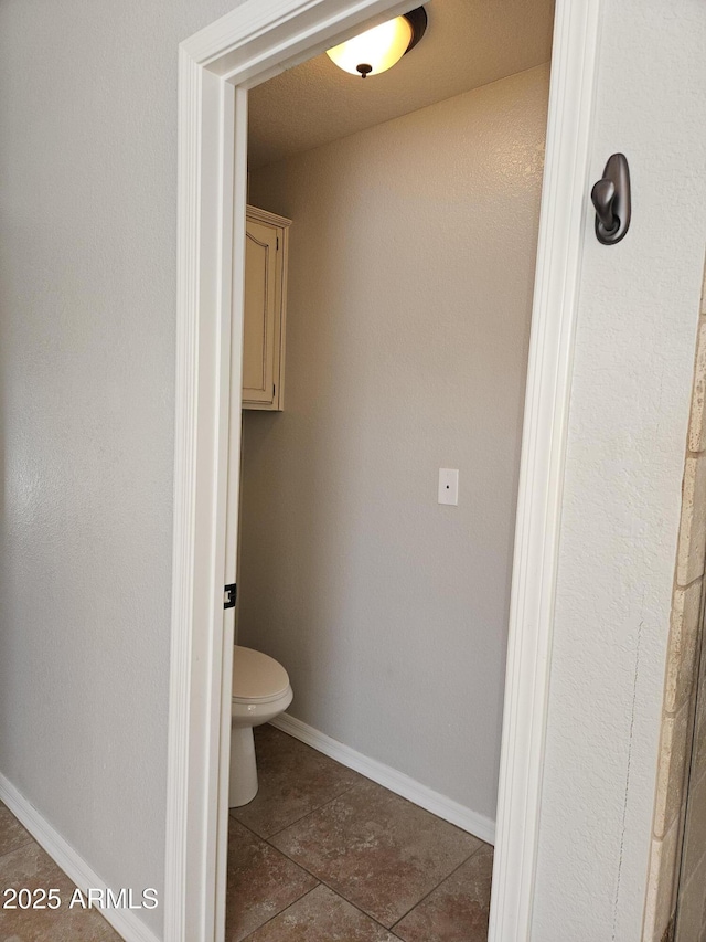 bathroom with toilet and baseboards